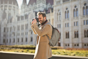 Un bărbat face o fotografie în fața unei clădiri istorice – un look stilat.